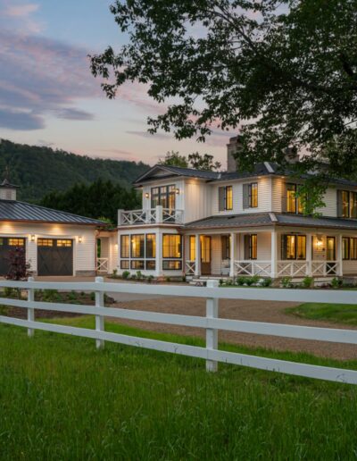 Beautifully transformed farmhouse with stone accents, a front porch, and well-landscaped gardens.